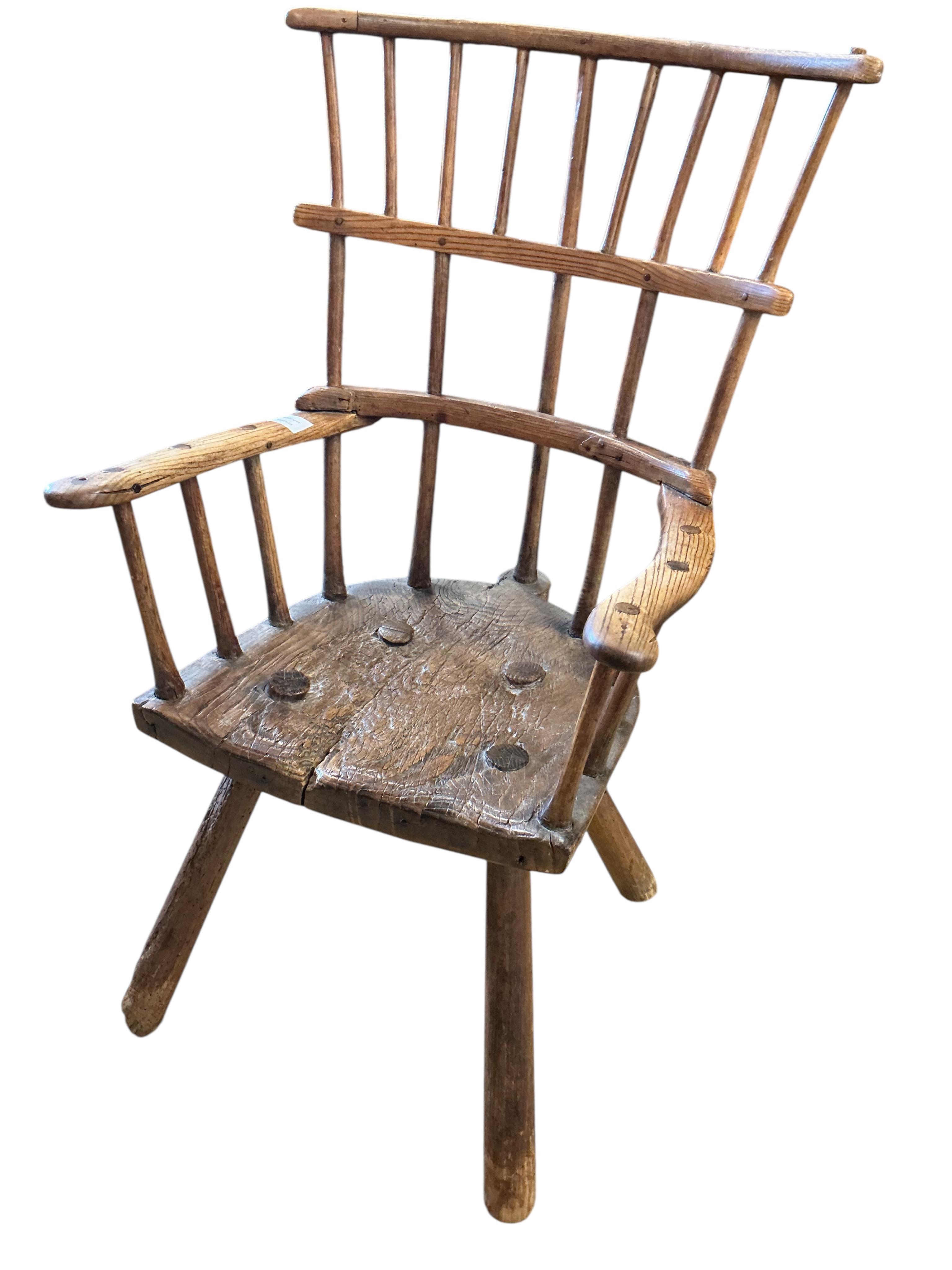 An 18th or 19th century primitive ash and elm Windsor armchair